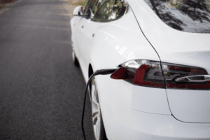 tesla is not charging, auto repair in Wake Forest, NC at Pleasant Automotive. Image of a white electric vehicle connected to a charging station.