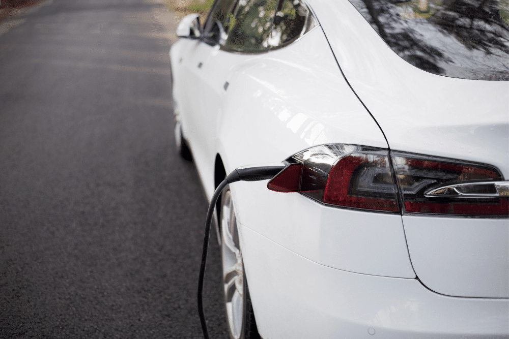 tesla is not charging, auto repair in Wake Forest, NC at Pleasant Automotive. Image of a white electric vehicle connected to a charging station.