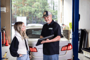 european auto repair, Auto Repair Services in Wake Forest, NC at Pleasant Automotive. Image of a mechanic showing a diagnostic report to a customer inside a repair shop, demonstrating transparency and trusted service.