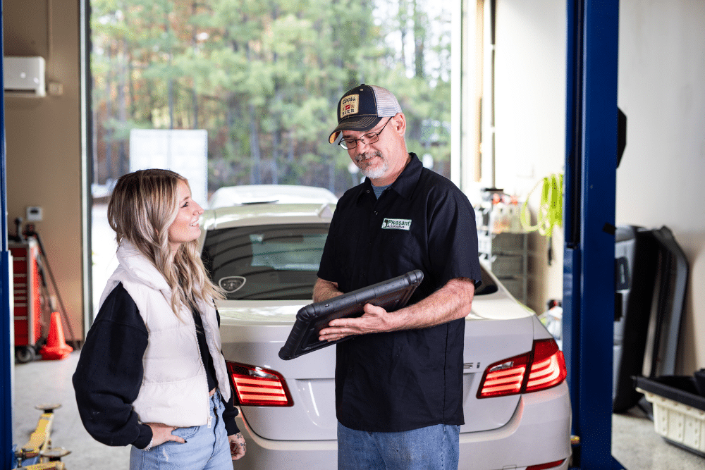 european auto repair, Auto Repair Services in Wake Forest, NC at Pleasant Automotive. Image of a mechanic showing a diagnostic report to a customer inside a repair shop, demonstrating transparency and trusted service.
