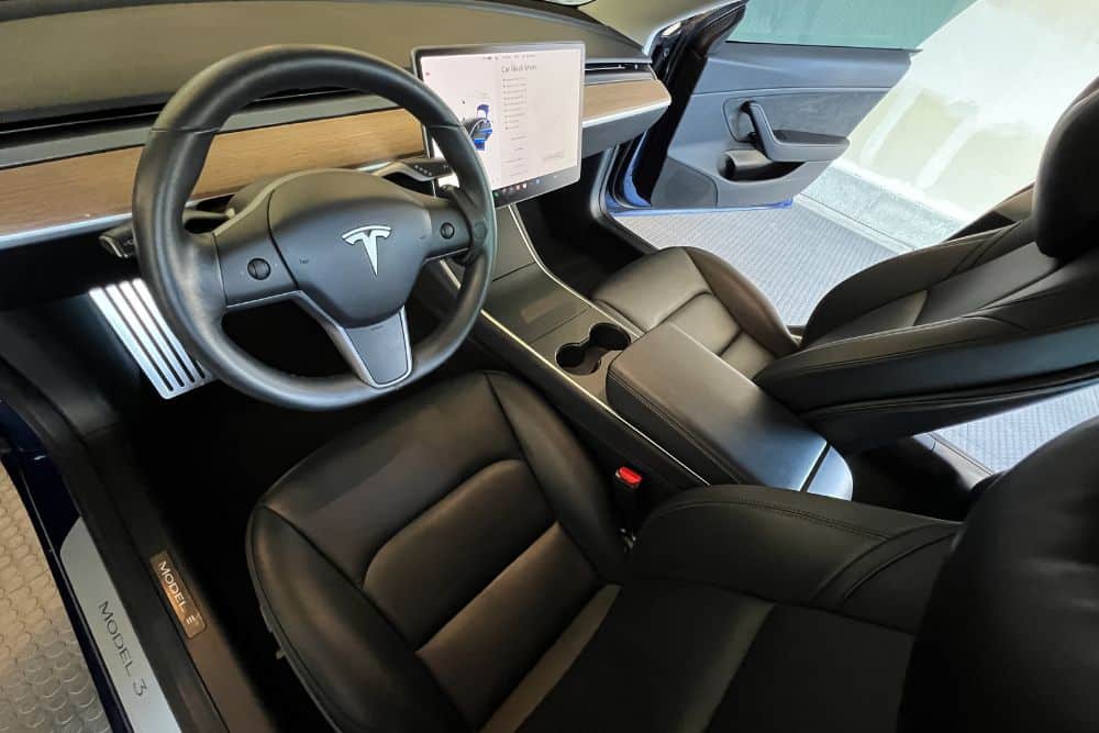 Tesla maintenance in Wake Forest, NC by Pleasant Automotive. Interior of a Tesla Model 3 with touchscreen display during inspection.