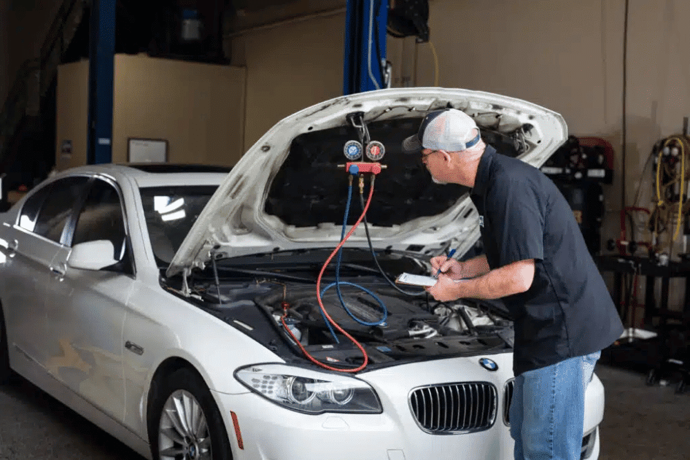A/C repair in by Pleasant Automotive in Wake Forest, NC, A mechanic checks a car's cooling system during routine maintenance